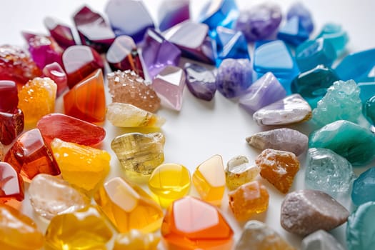 Rainbow-colored chakra stones transparently arranged in a circular pattern