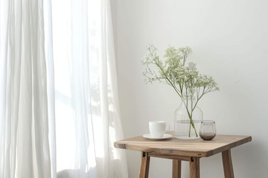 A table with a vase of flowers and a cup of coffee. The table is in a room with white walls and a window