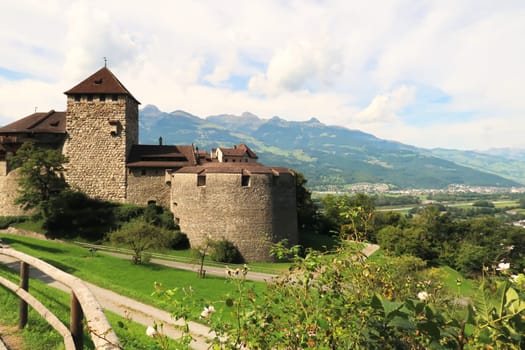 View from above onto the Vaduz Castle, Schloss Vaduz, the palace and official residence of the Prince of Liechtenstein, a rose bush is growin in the foreground, Vaduz, Liechtenstein 2022
