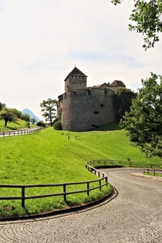 A cobble stone road, street is winding its way up to the Vaduz Castle, Schloss Vaduz, the palace and official residence of the Prince of Liechtenstein in Vadzu, Liechtenstein 2022