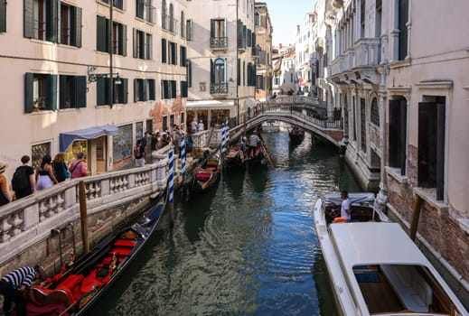 Venice, Italy - September 5, 2022: One of the most recognizable tourist attractions in the world - a gondola cruise through the narrow canals in Venice