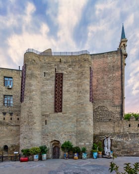 Exterior of the Quadrangular Tower in Baku, Azerbaijan, showing the stone facade and a doorway. The tower is part of the citys ancient walls