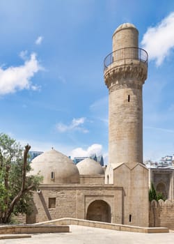 The Shah Mosque minaret rises above the surrounding buildings in Baku, Azerbaijan. Attached to the Palace of the Shirvanshahs, this mosque is a prominent landmark in the city