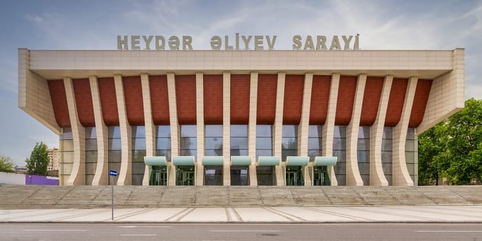 The heydar aliyev palace in baku blends soviet modernist and azerbaijani styles, showcasing the city's cultural heritage with its grand facade and staircase