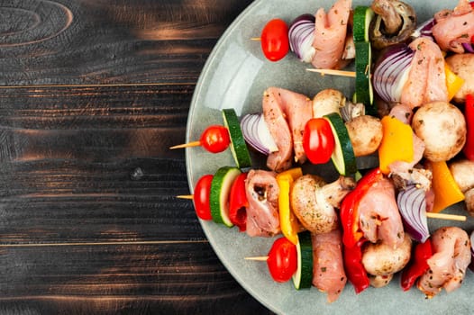 Raw fresh meat shish kebab with vegetables. Uncooked meat skewers. Close-up.