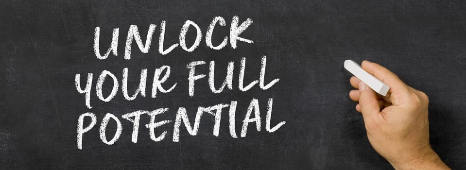 Text written on a blackboard - Unlock your full potential