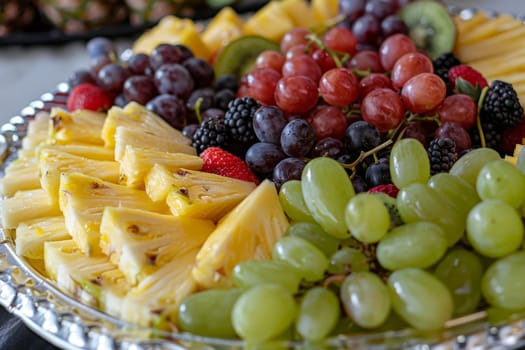 Close-up of a colorful fruit platter with pineapple, grapes, kiwi, and berries, a nutritious and refreshing snack