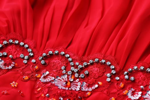 An elegant dress with lace, pearls and glittering stones in red