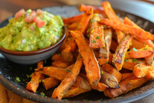Plate of baked sweet potato fries with a side of guacamole, a nutritious and satisfying snack or side dish