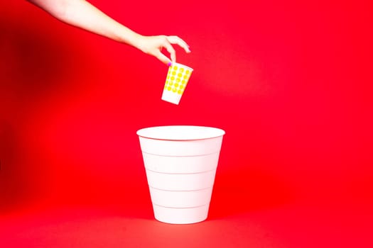 Closeup hand throwing empty paper disposable coffee cup in a recycling bin. Eco friendly concept.