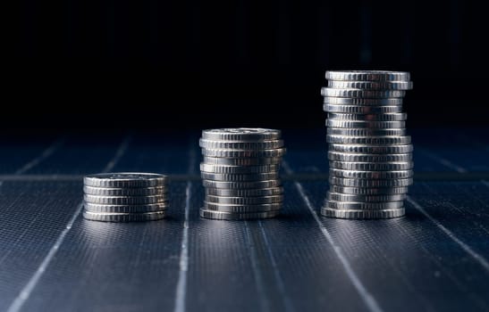 Stacks of metal coins on a black background, financial growth, price increases