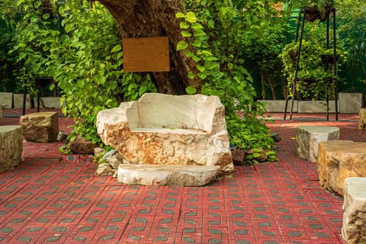 A large stone made into a chair to decorate the garden.