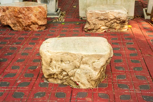 A large stone made into a chair to decorate the garden.