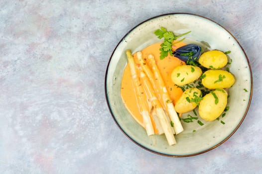 Vegan food, new boiled potatoes and white asparagus.