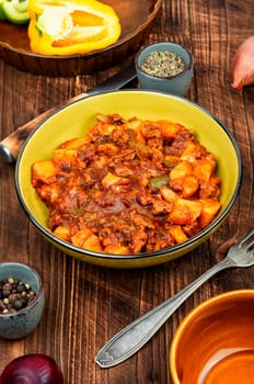 Stewed potatoes with minced turkey on rustic and wooden table. German cuisine. Ragout