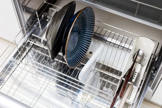 Dishwasher at the kitchen with dishes