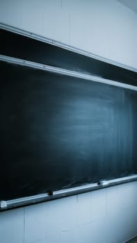 A clean, empty chalkboard in a classroom, ready for new lessons or messages. The image highlights the simplicity and potential of a blank slate.