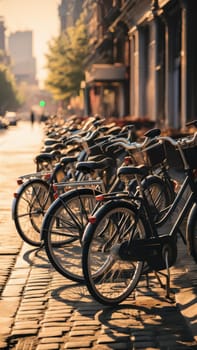 A row of bicycles parked on a sunny street in an urban area, with a warm golden glow illuminating the scene.Suitable for urban lifestyles and eco-friendly content.