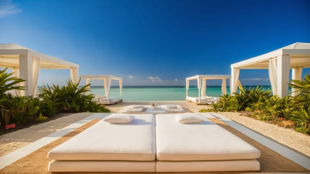 A luxurious beachside lounging area with white canopies and comfortable sunbeds overlooking the calm turquoise sea.Suitable for travel brochures, resort advertisements, and vacation planning content.