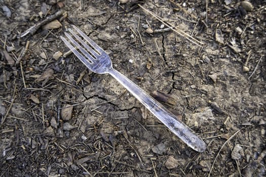 Detail of plastic fork thrown in nature, pollution