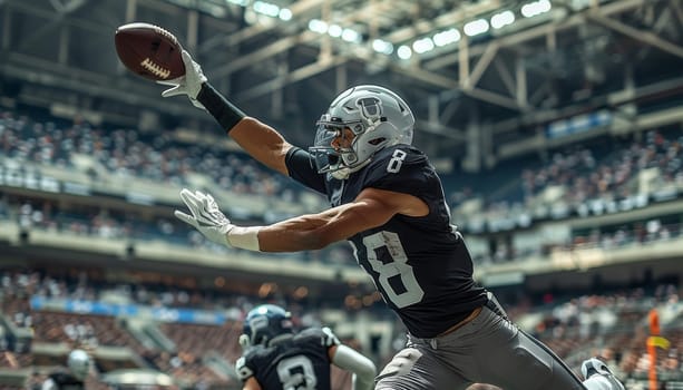 A football player in a black jersey and white helmet leaps through the air, catching the ball with his outstretched arms. The player is in the middle of a game, and the stadium is packed with excited fans. The players determination and focus are palpable as he focuses on securing the ball and making a play.