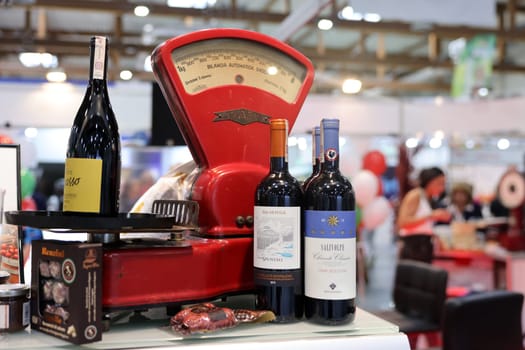 Cracow, Poland - November 5, 2021: bottles of Italian wine and old shop scale at Enoexpo and Gastrofood - Trade Fair for Food and Drinks for Catering