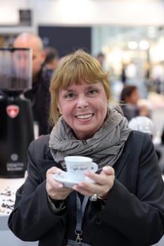 Cracow, Poland - November 3, 2021: Woman tasting Italian Caffe Napoli at Enoexpo and Gastrofood - Trade Fair for Food and Drinks for Catering