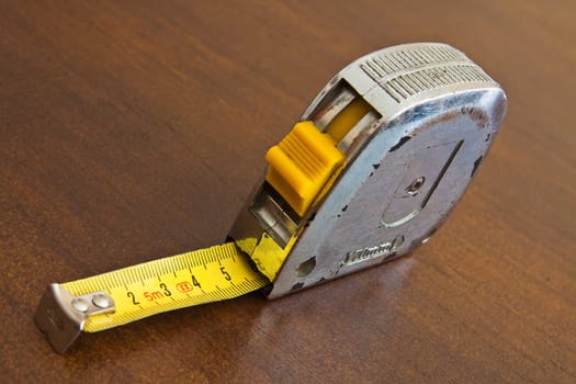 Centimeter tape worn by long use on wooden board