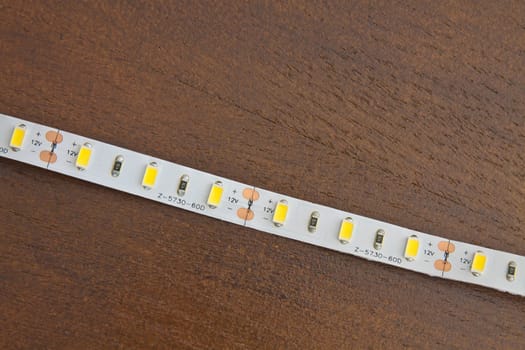 LED strip wound on a roll of brown wooden board