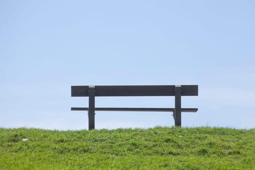 Wooden bench on a dyke, blue sky, Germany