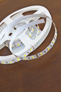 LED strip wound on a roll of brown wooden board