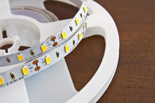 LED strip wound on a roll of brown wooden board