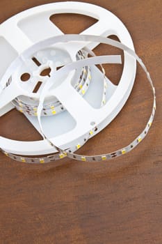 LED strip wound on a roll of brown wooden board
