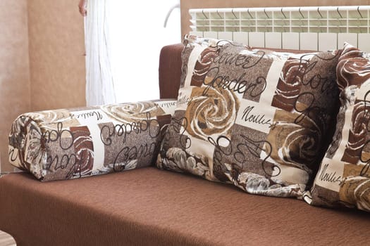 Detail from home sofa with pillows in beige brown tones