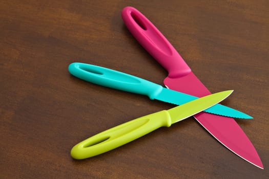 Set of large and small serrated kitchen knives color on a wooden board