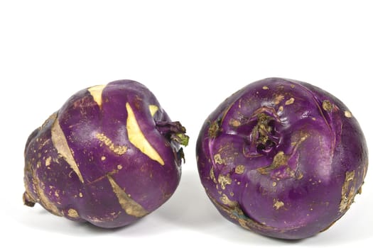 Kohlrabi vegetable with a rounded stem with dark purple color on a white background