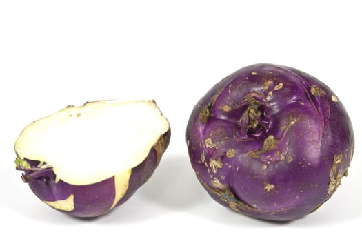 Kohlrabi vegetable with a rounded stem with dark purple color on a white background
