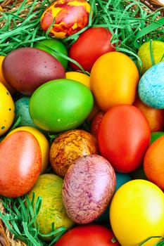 Colorful dyed Easter eggs placed in a wooden basket