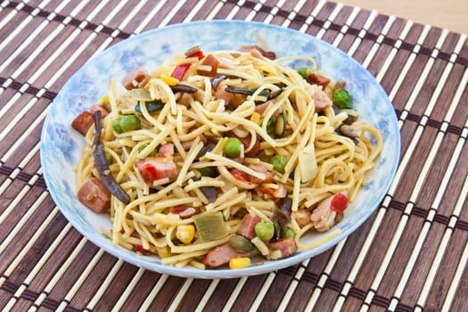 Yellow noodles cooked with Chinese vegetable mix and smoked bacon