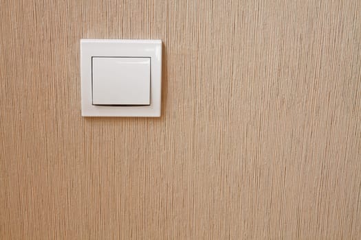 Installation of new power switch on the wall lined with wallpaper wall