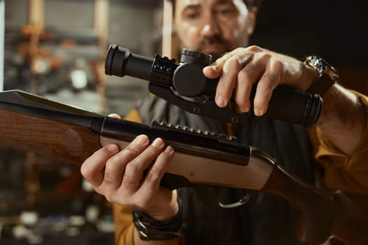 Salesman demonstrating professional accuracy gun assembly with telescopic sight. High quality hunting store assortment showcase