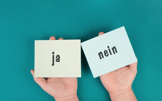 Yes and no is standing in german language on the paper, choosing a direction, new opportunity, decision making concept, following a challenge