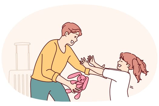 Little girl runs to father who returned from long business trip with gift and wants to hug daughter. Man with toy hare in hand stands near suitcase and rejoices when he sees daughter running towards