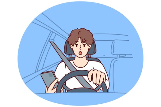 Distracted man driver with phone sits behind wheel of car and gets scared sees obstacle on road or sharp turn. Shocked driver not following traffic rules using smartphone while driving