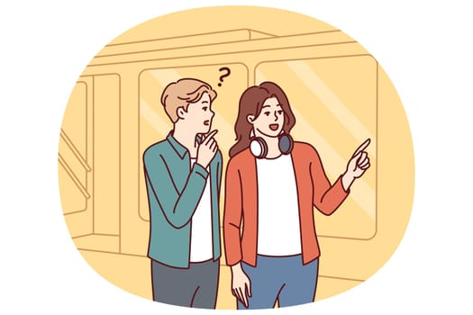 Man and woman are standing near subway or tamway car, choosing shortest path and discussing where to go next. Girl with headphones around neck helps tourist who has lost his way to choose path