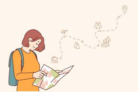 Woman tourist uses paper map to travel through nature reserves and plot route to destination. Smiling girl traveler plans tour route and chooses natural attractions worthy of visiting