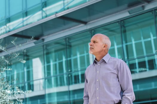Businessman thinking outside a modern office, reflecting on technology's impact on society and the environment