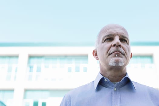 Mature businessman is looking up with a thoughtful expression, contemplating the possibilities and challenges that lie ahead