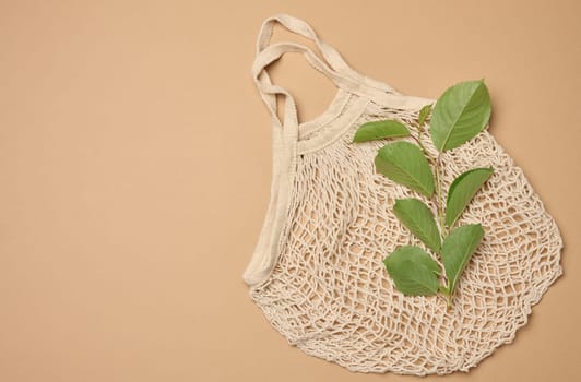 Textile grocery bag on brown background, top view. Copy space