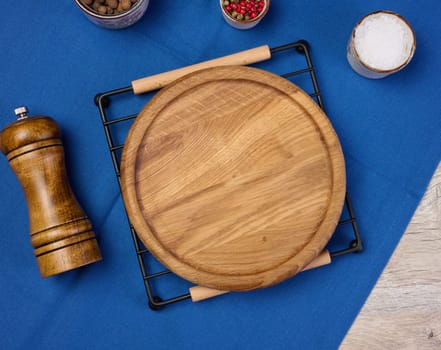 Round empty wooden plate on the table, top view